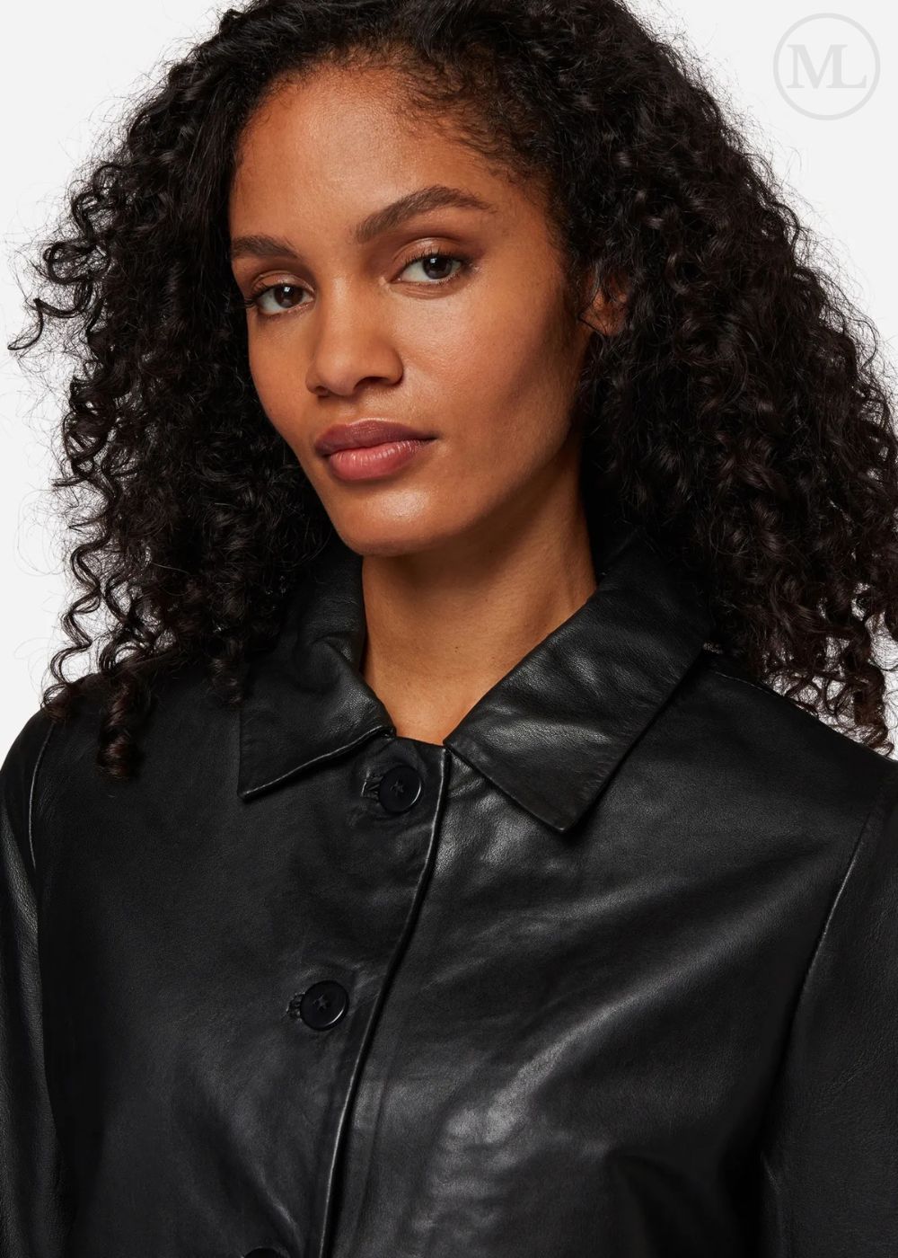 Femme portant une veste courte en cuir noir sur un fond blanc