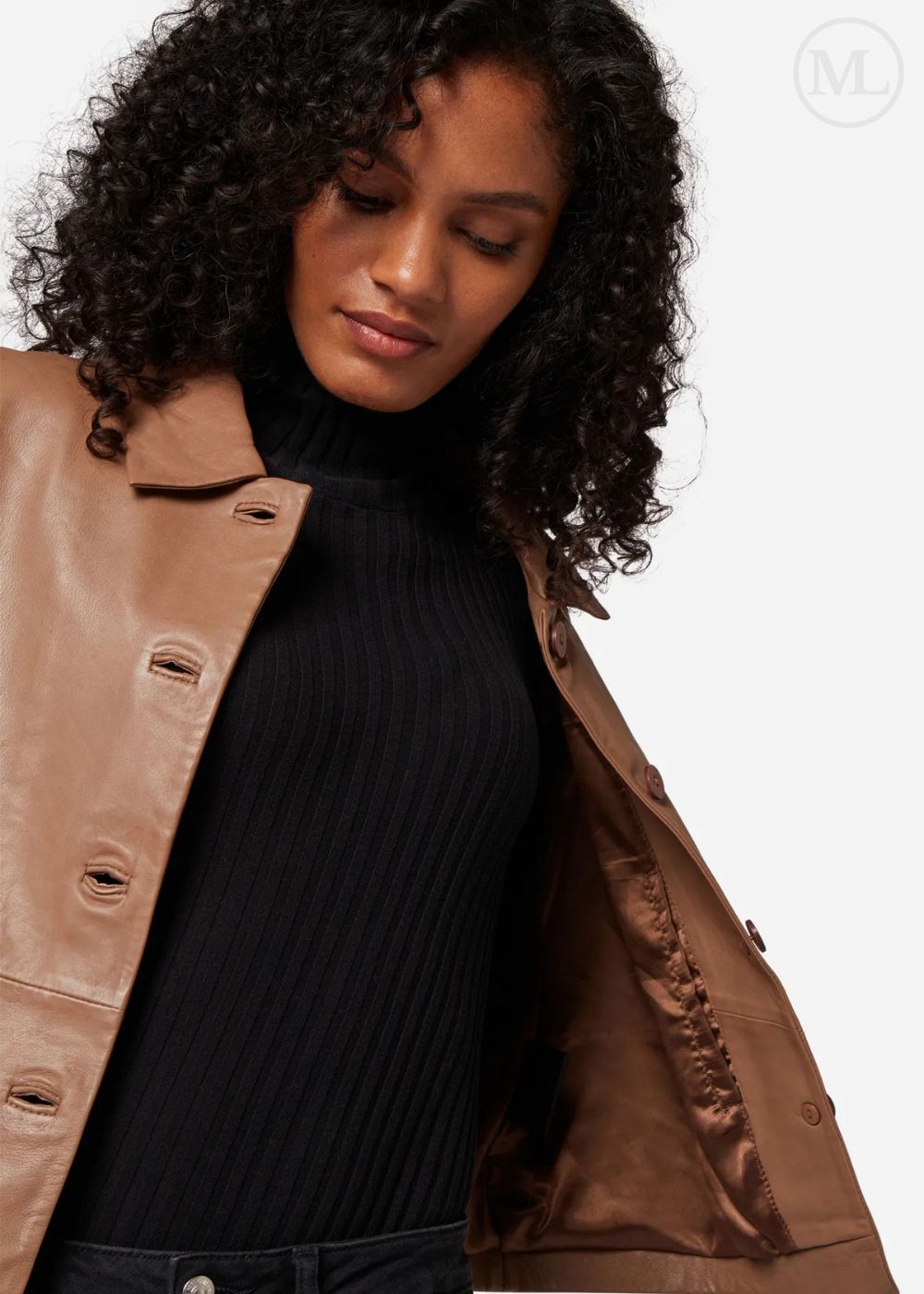 Woman wearing a camel leather cropped jacket over a black turtleneck on a white background
