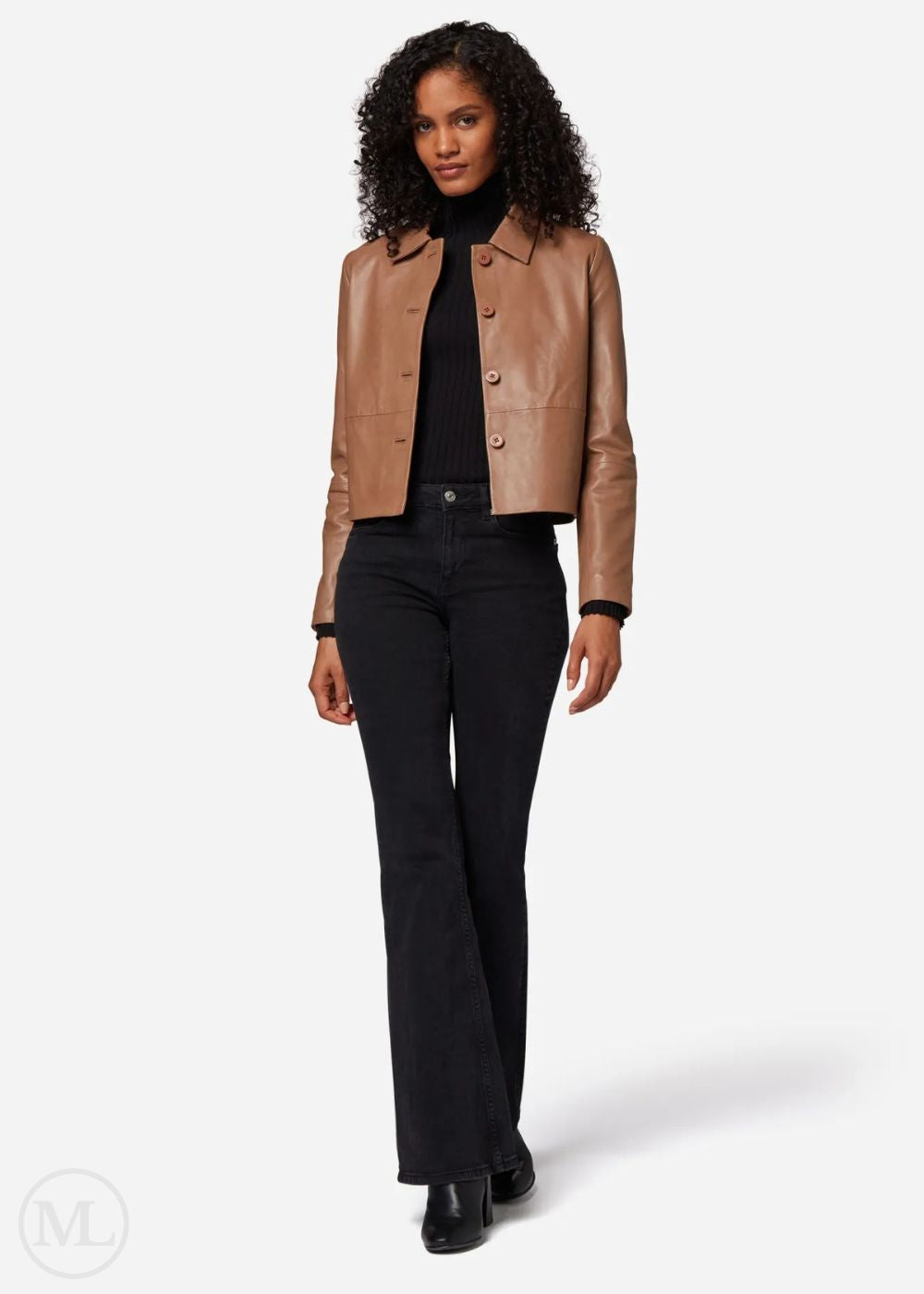 Woman wearing a camel leather crropped jacket and black pants on a white background