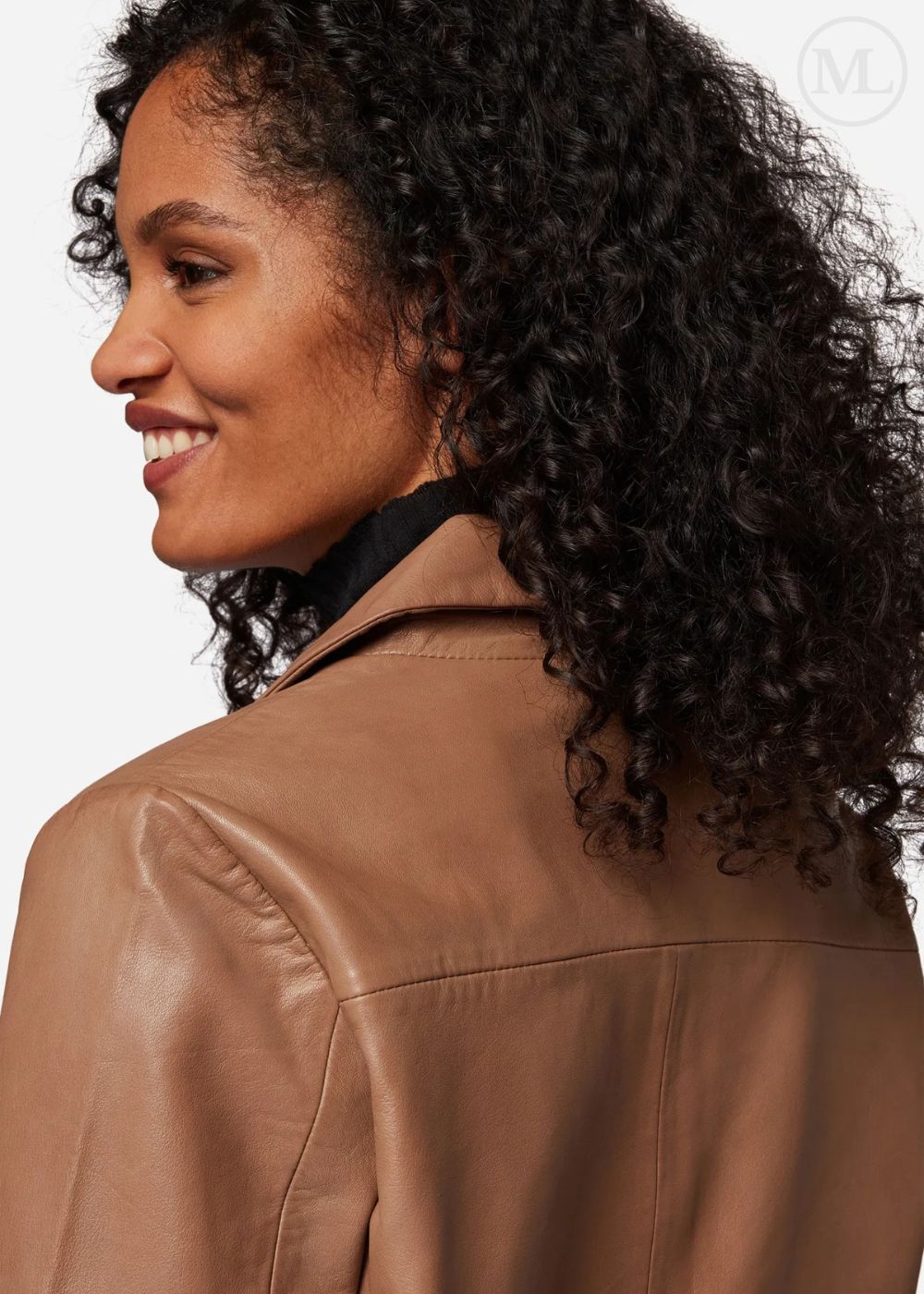 Woman wearing a camel leather cropped jacket with a neutral background