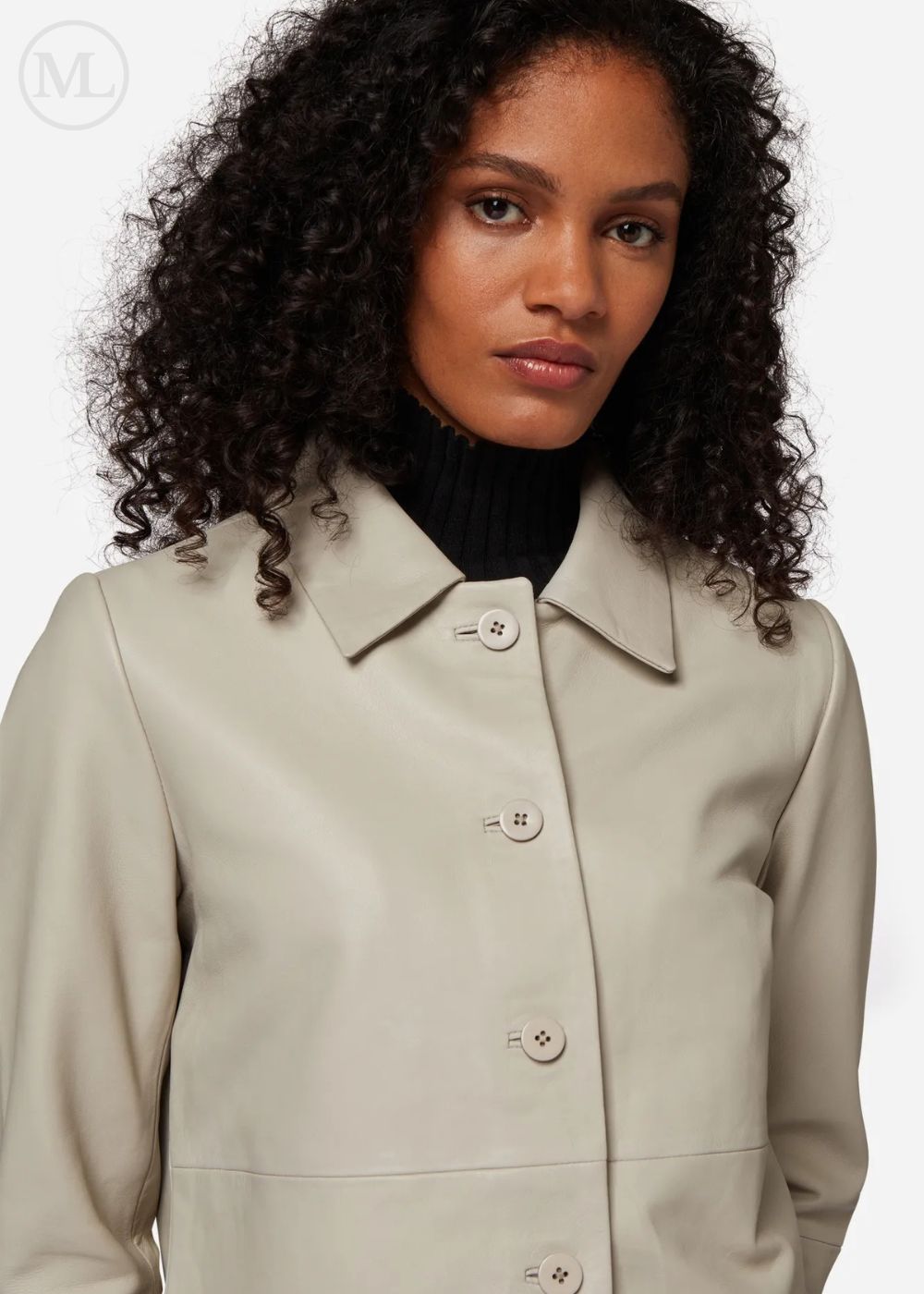 Woman wearing a lvory leather cropped jacket coat with a plain background