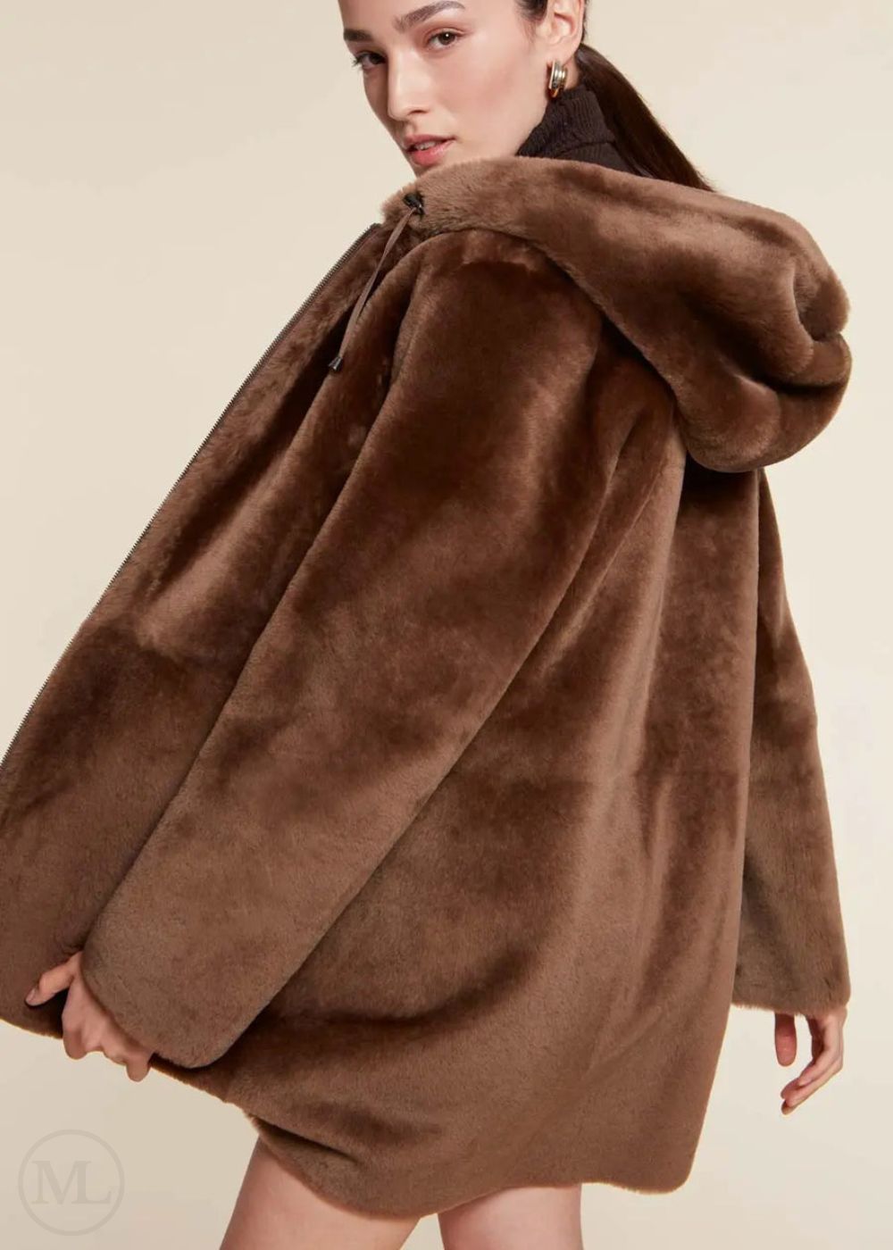 Woman wearing a brown shearling wool fur coat against a beige background