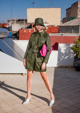 Women wearing a Olive Green Leather coat and hat on a rooftop with buildings in the background