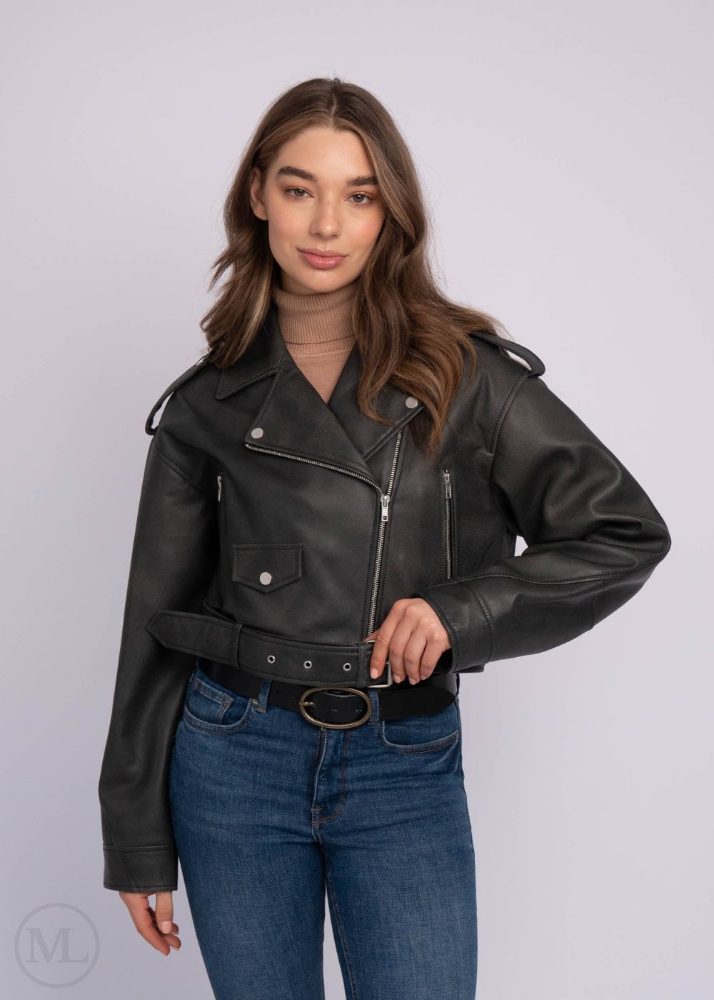 Femme portant une veste en cuir noire et un jean bleu sur fond blanc
