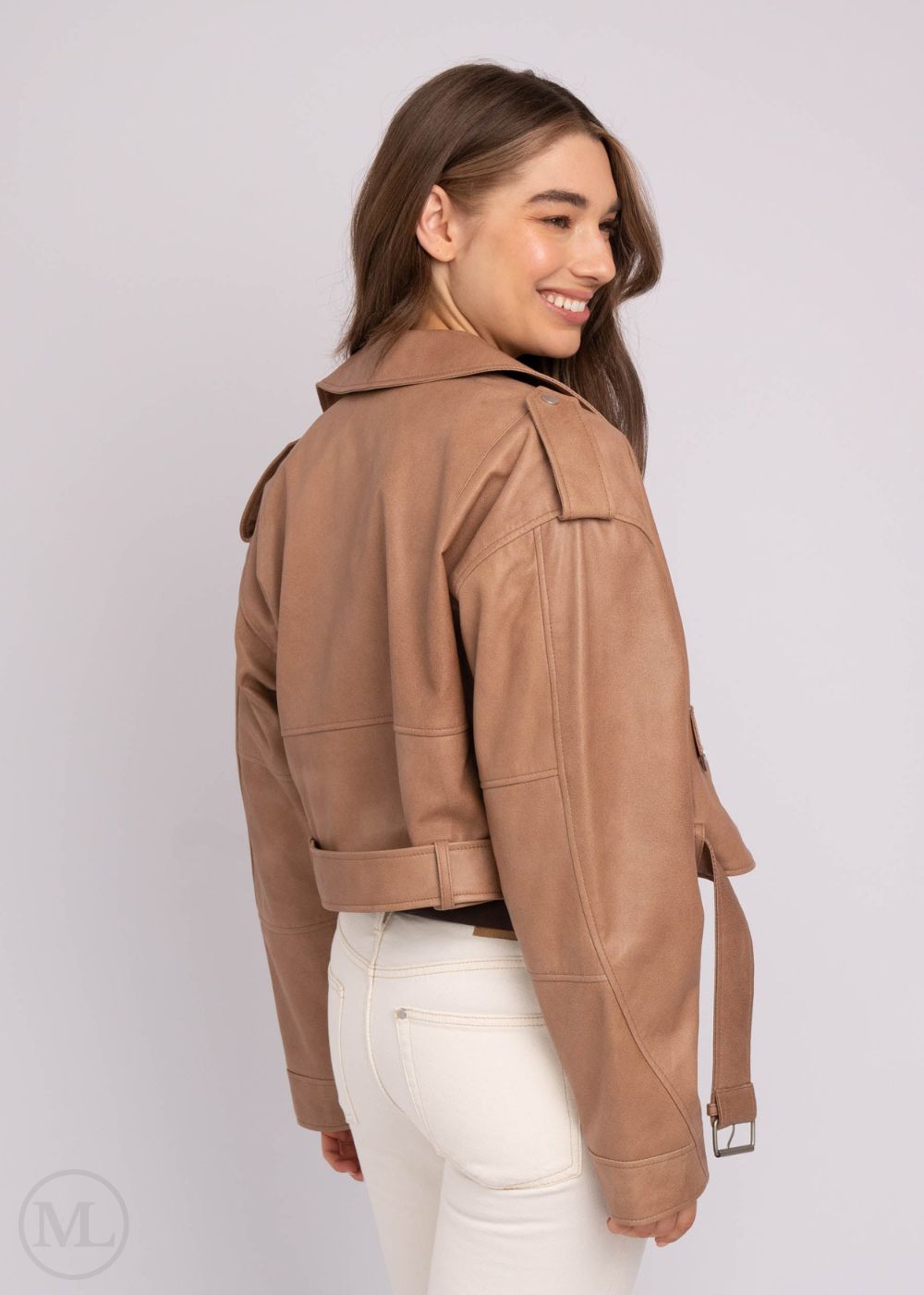 Woman wearing a taupe leather jacket on a plain background