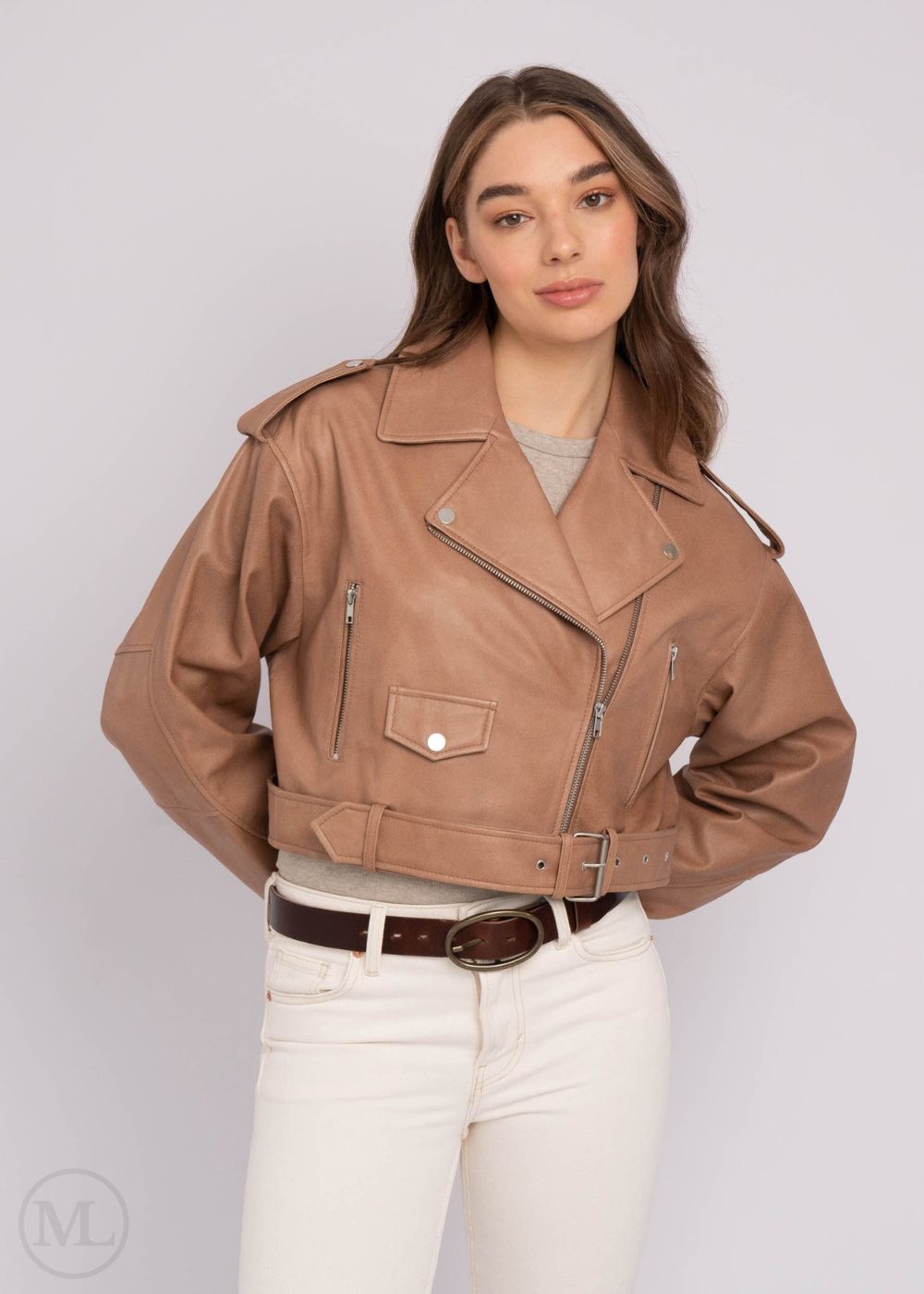 Woman wearing a taupe leather jacket on a plain background