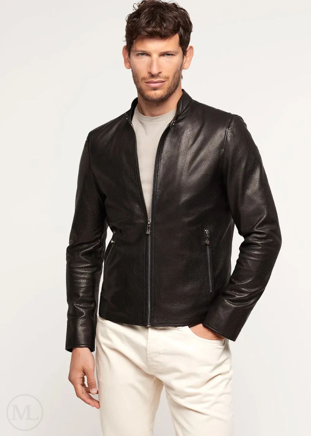 Man wearing a black lambskin leather jacket and white pants on a light gray background