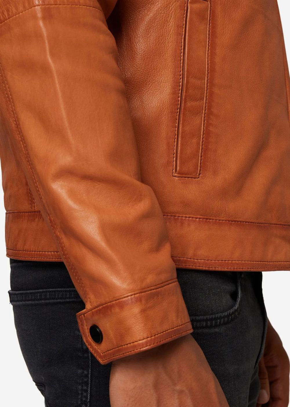 Close-up of a cognac brown leather jacket worn by a man with a white background