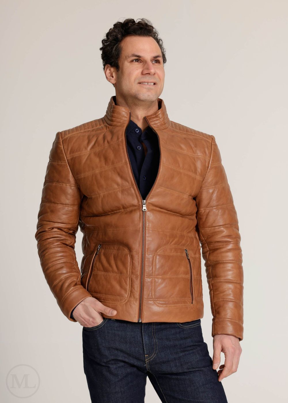 Man wearing a cognac brown leather jacket on a plain background