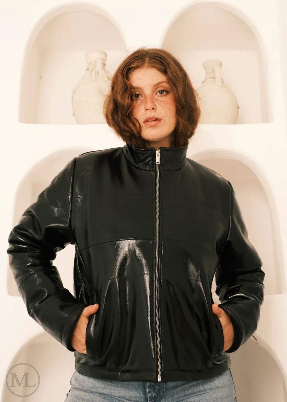 Women wearing a black leather Puffer jacket in front of white abstract art