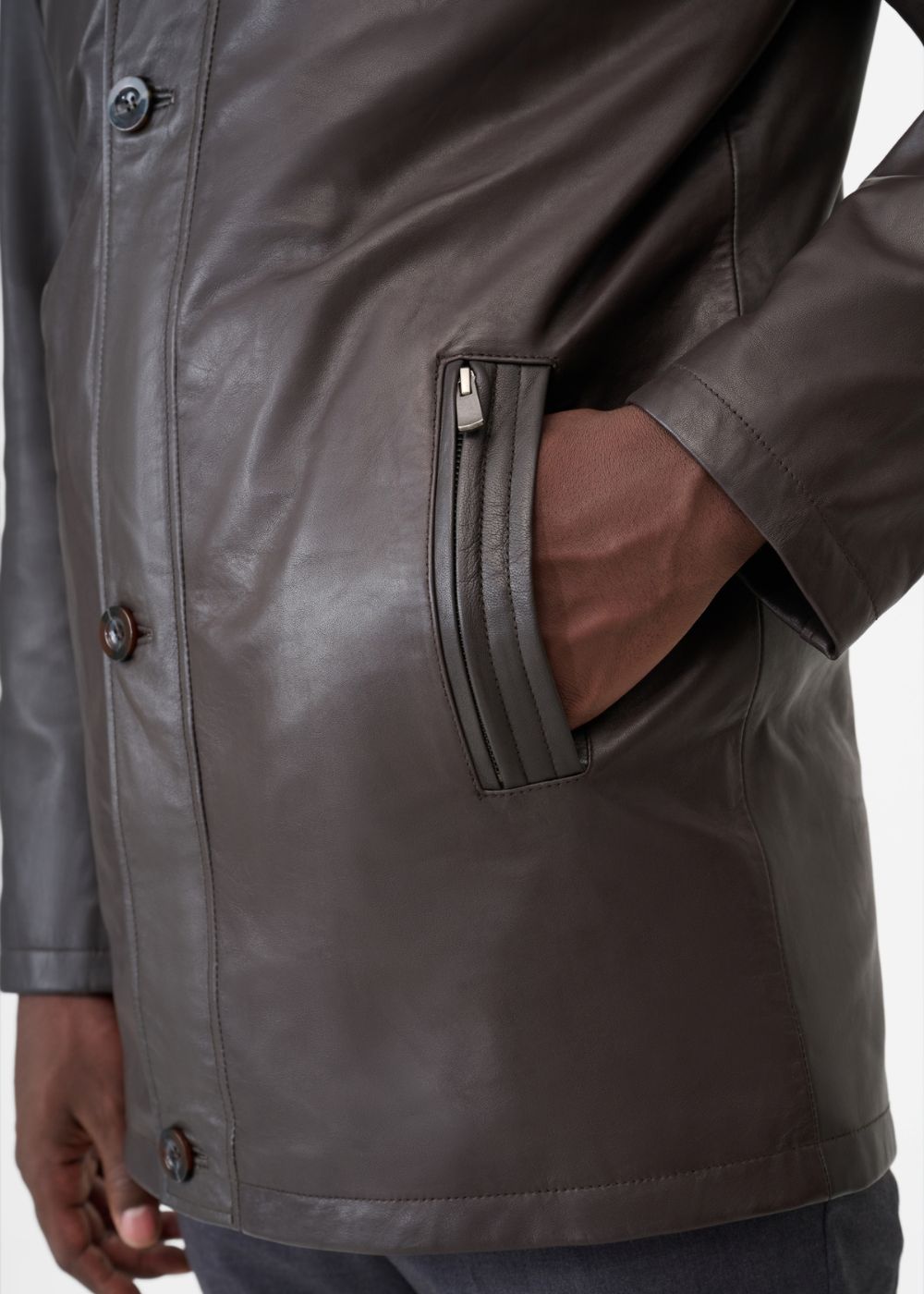 Close-up of a brown coat with a zipper pocket on a white background
