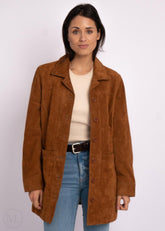 Woman wearing a cognac brown suede leather coat on a white background