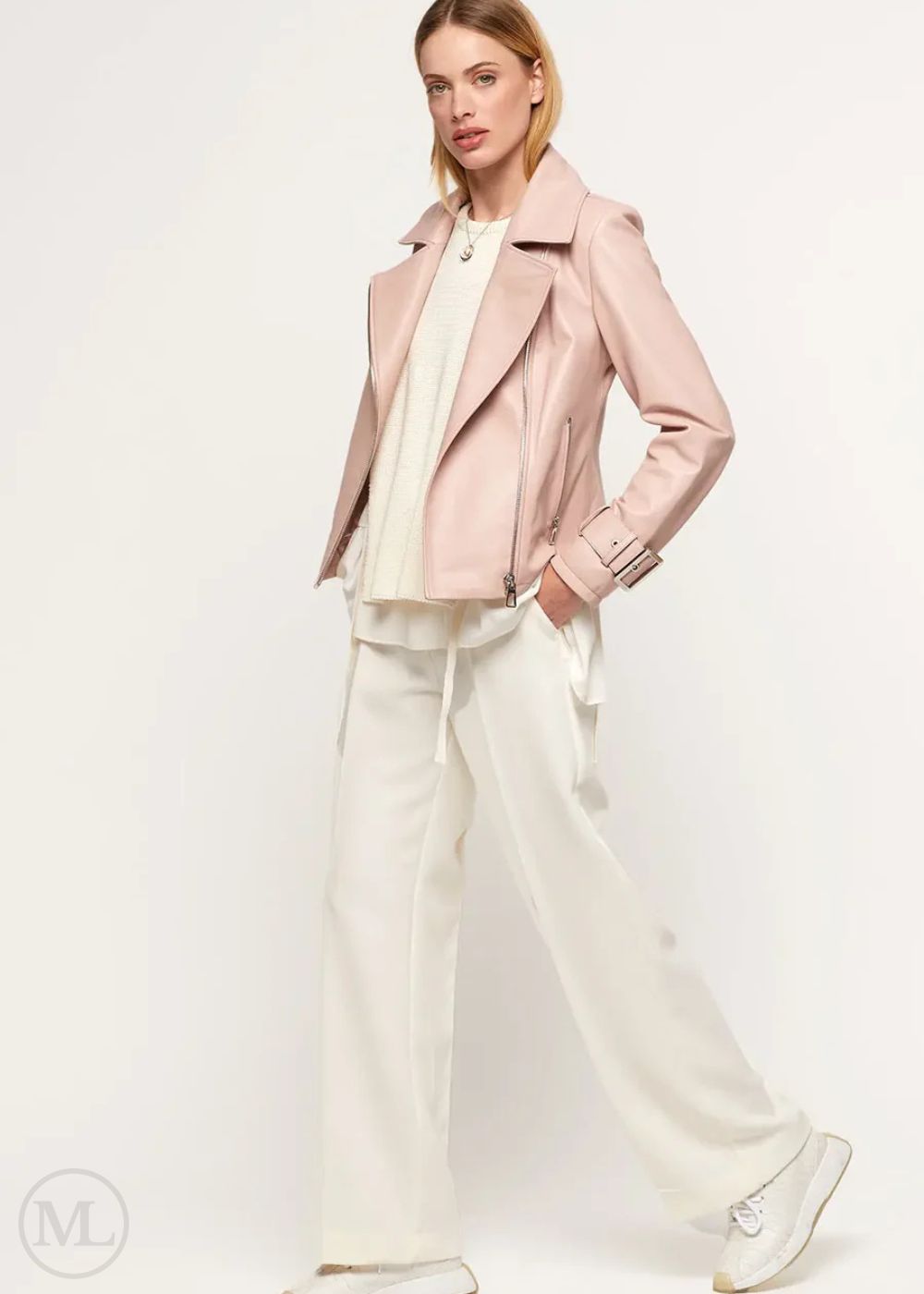 Woman wearing a fuschia leather biker jacket over a white outfit on a white background