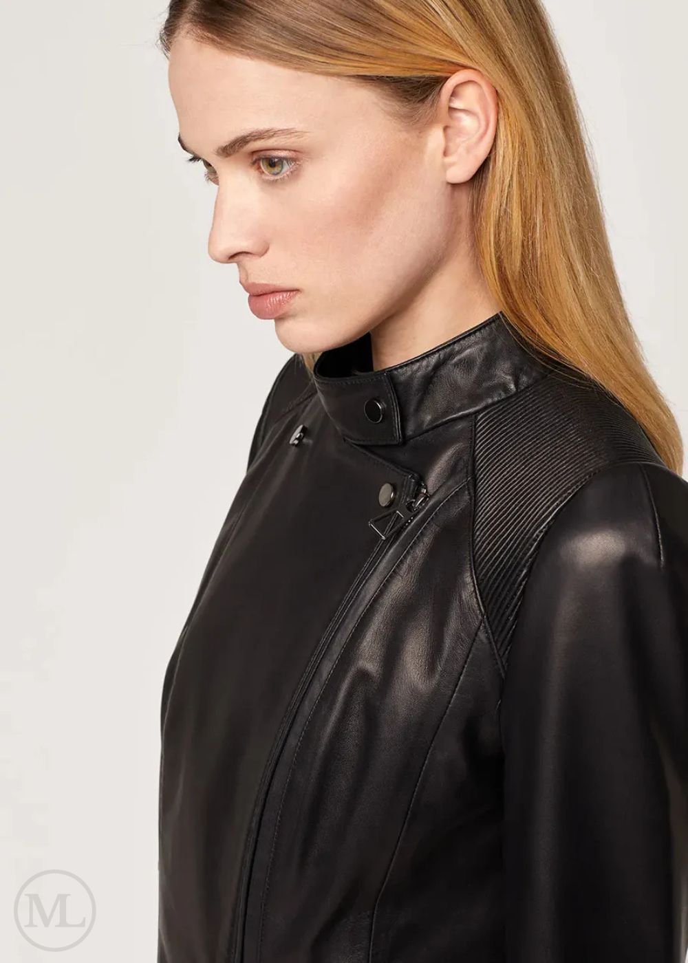 Woman wearing a black leather biker jacket on a plain background