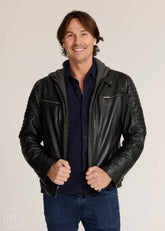 Man wearing a black leather Motorcycle jacket over a dark shirt on a plain background