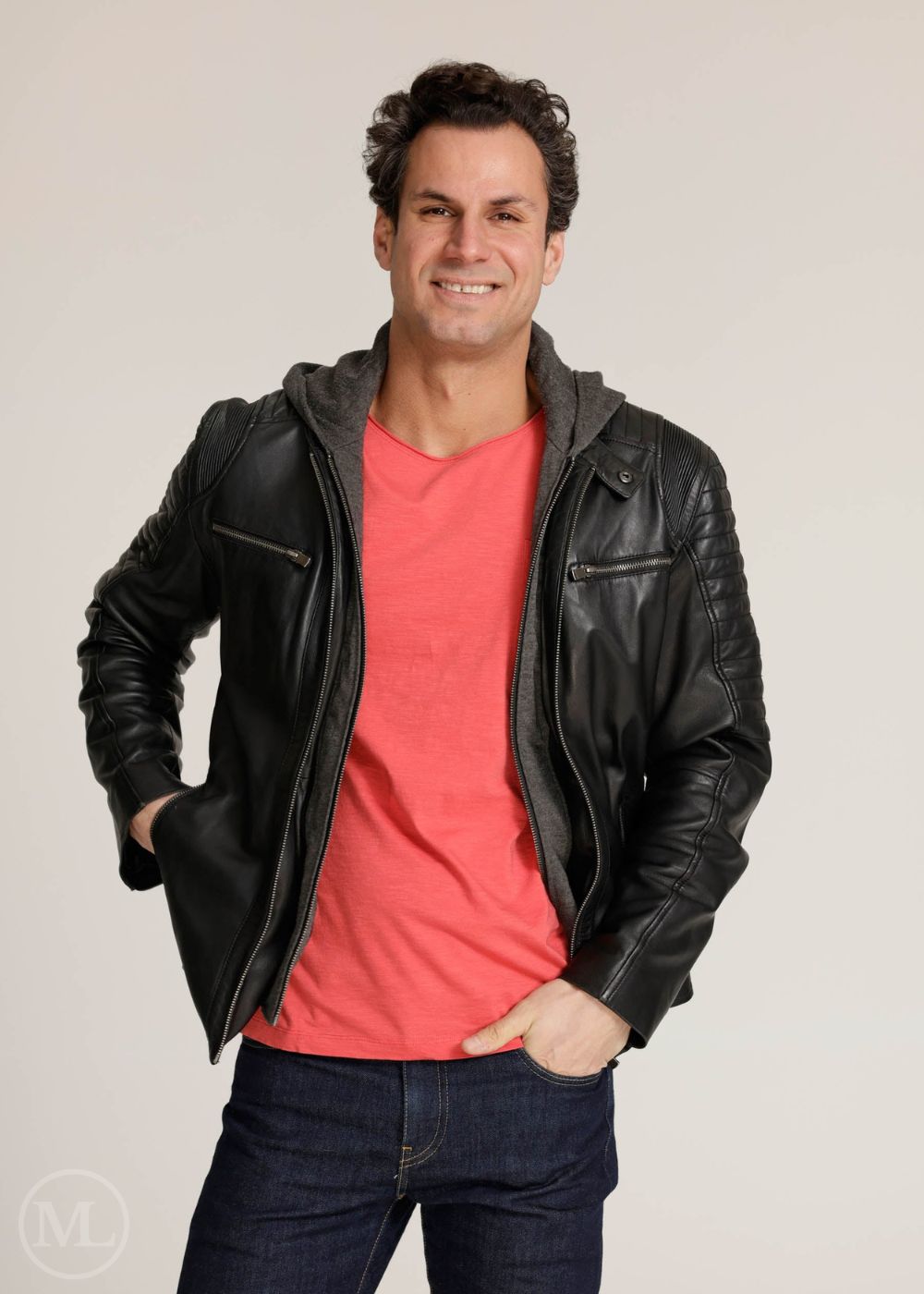 Man wearing a black leather Motorcycle jacket over a red shirt on a plain background