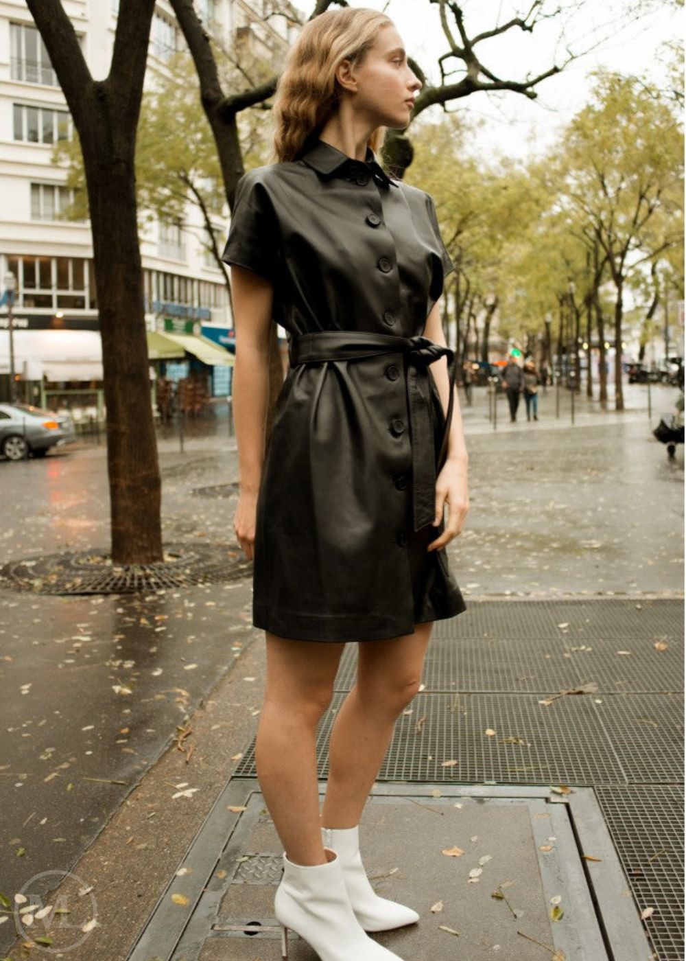 Femme portant une robe en cuir noir dans une rue de la ville