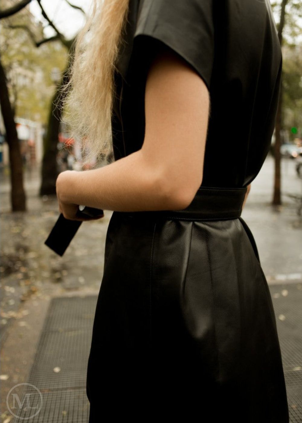 lady wearing a black leather dress on a city street - close shot sideways
