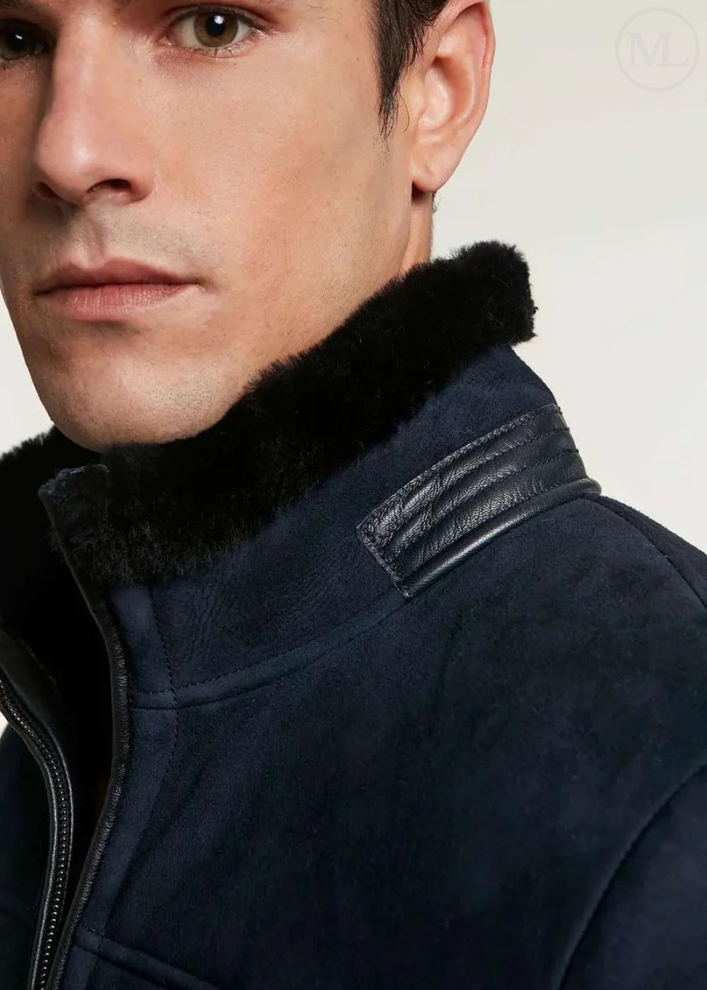 Close-up of a man wearing a navy blue jacket with a fur-lined hood.