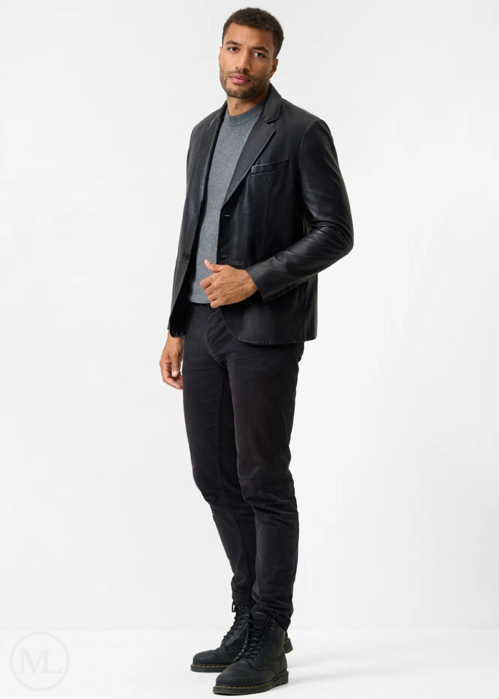 Man wearing a black leather blazer jacket, gray shirt, and black pants on a white background