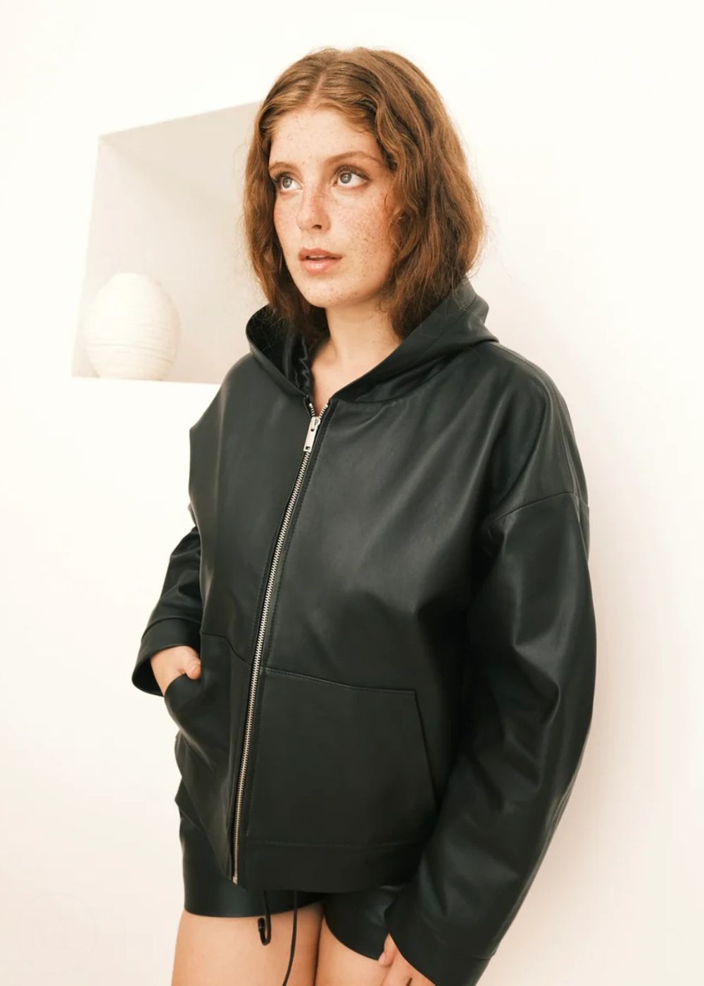 Women wearing a black Hoodie jacket against a white background