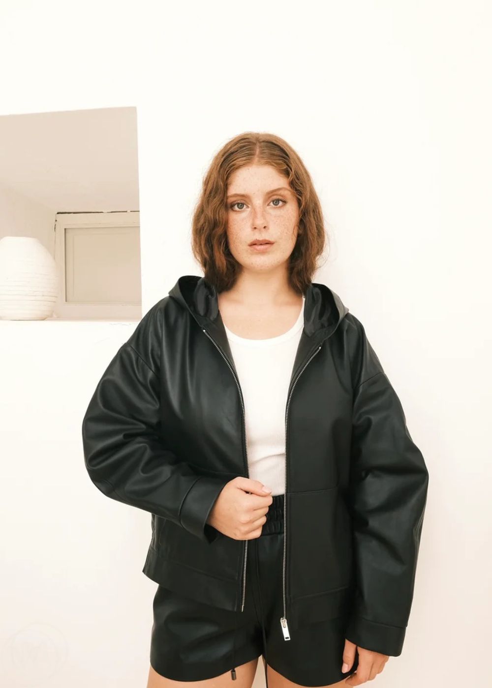 Women wearing a black Hoodie jacket against a white background