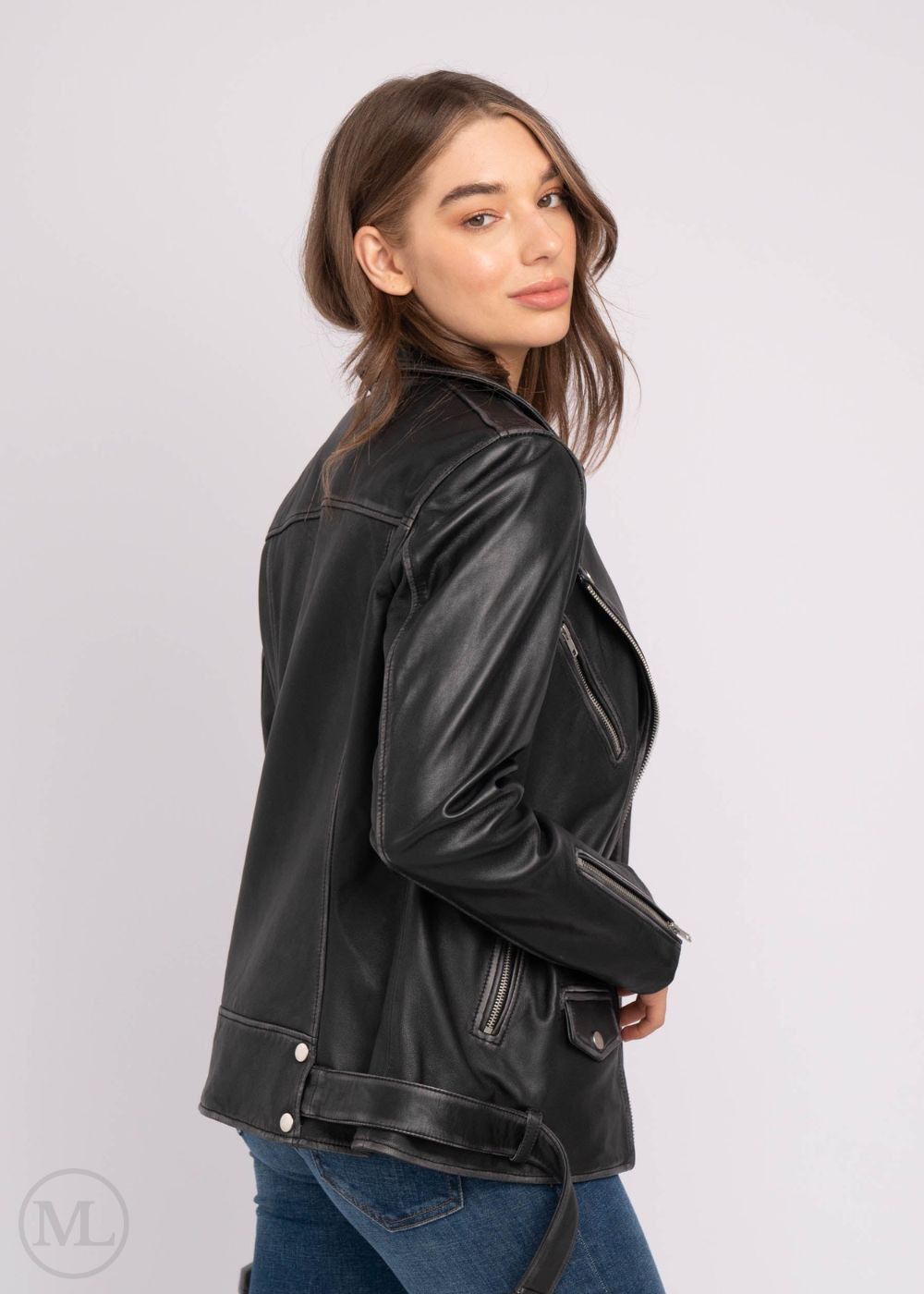 Femme portant une veste de motard en cuir noir sur fond blanc