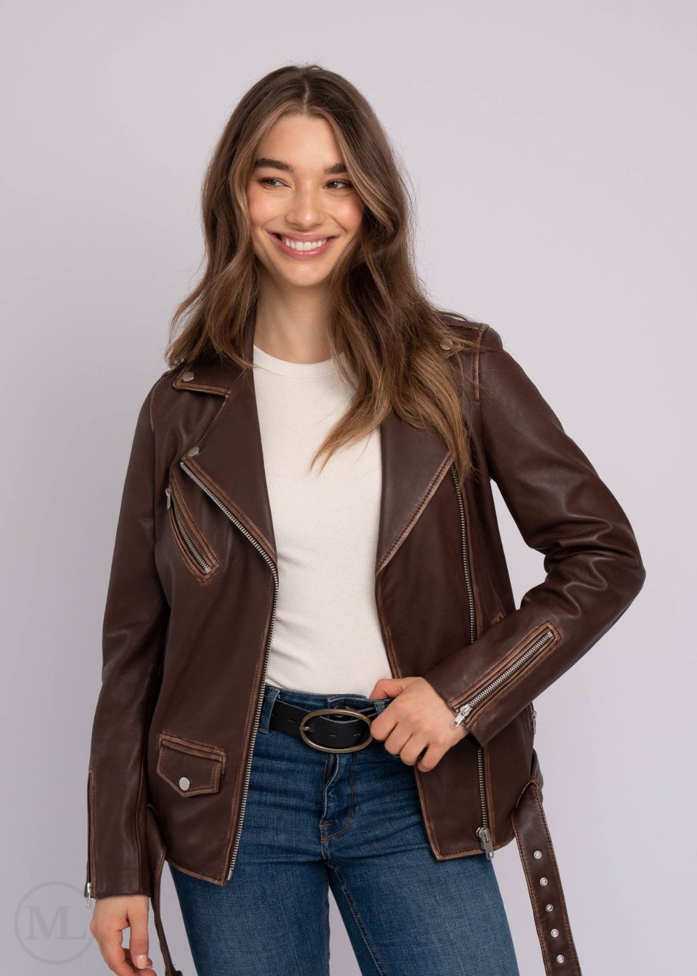 Woman wearing a brown leather biker jacket on a plain background