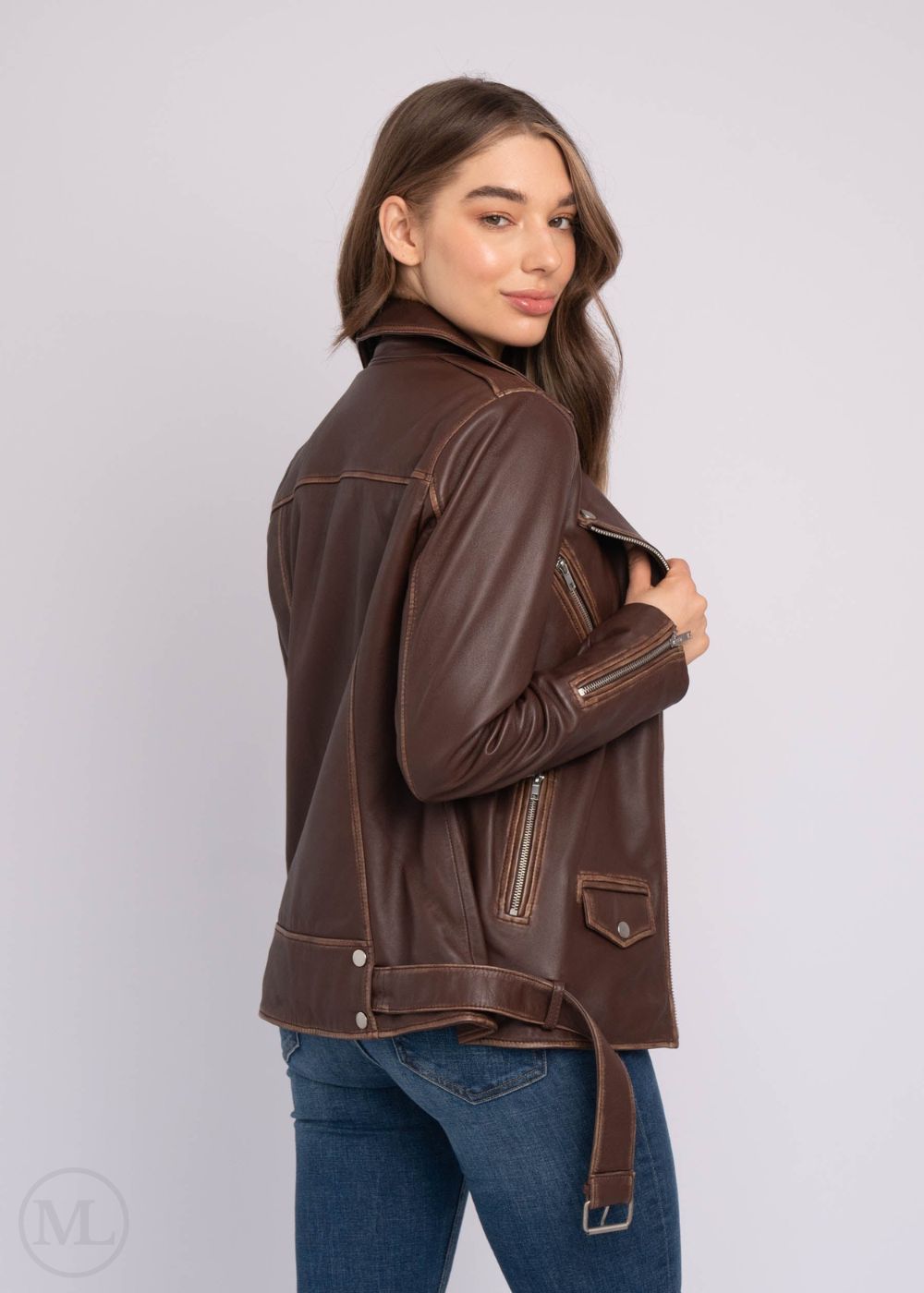 Woman wearing a brown leather biker jacket on a white background