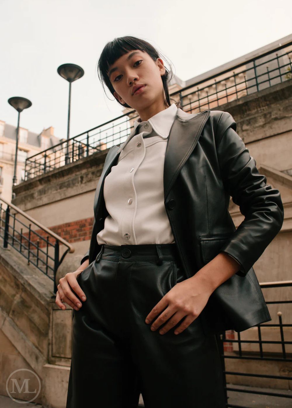 Women wearing a black leather Blazer jacket and black pants standing on a city street