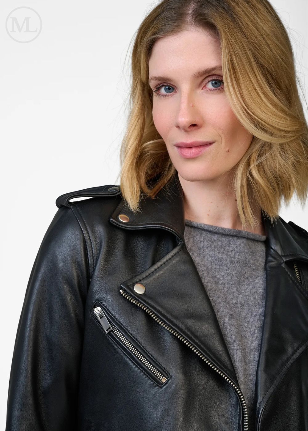 Femme portant une veste de motard en cuir noir sur fond blanc