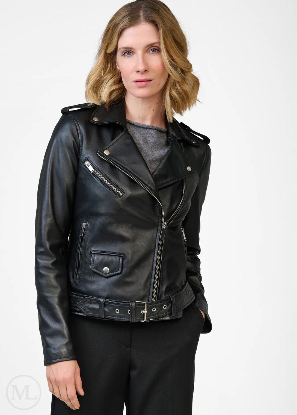 Femme portant une veste de motard en cuir noir sur fond blanc