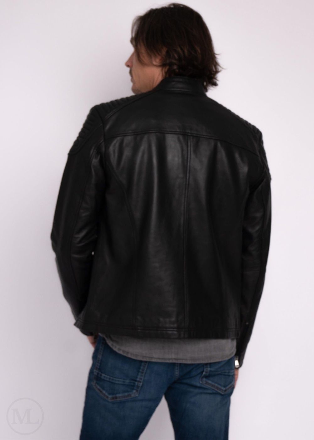 Man wearing a black leather jacket and blue jeans against a white background