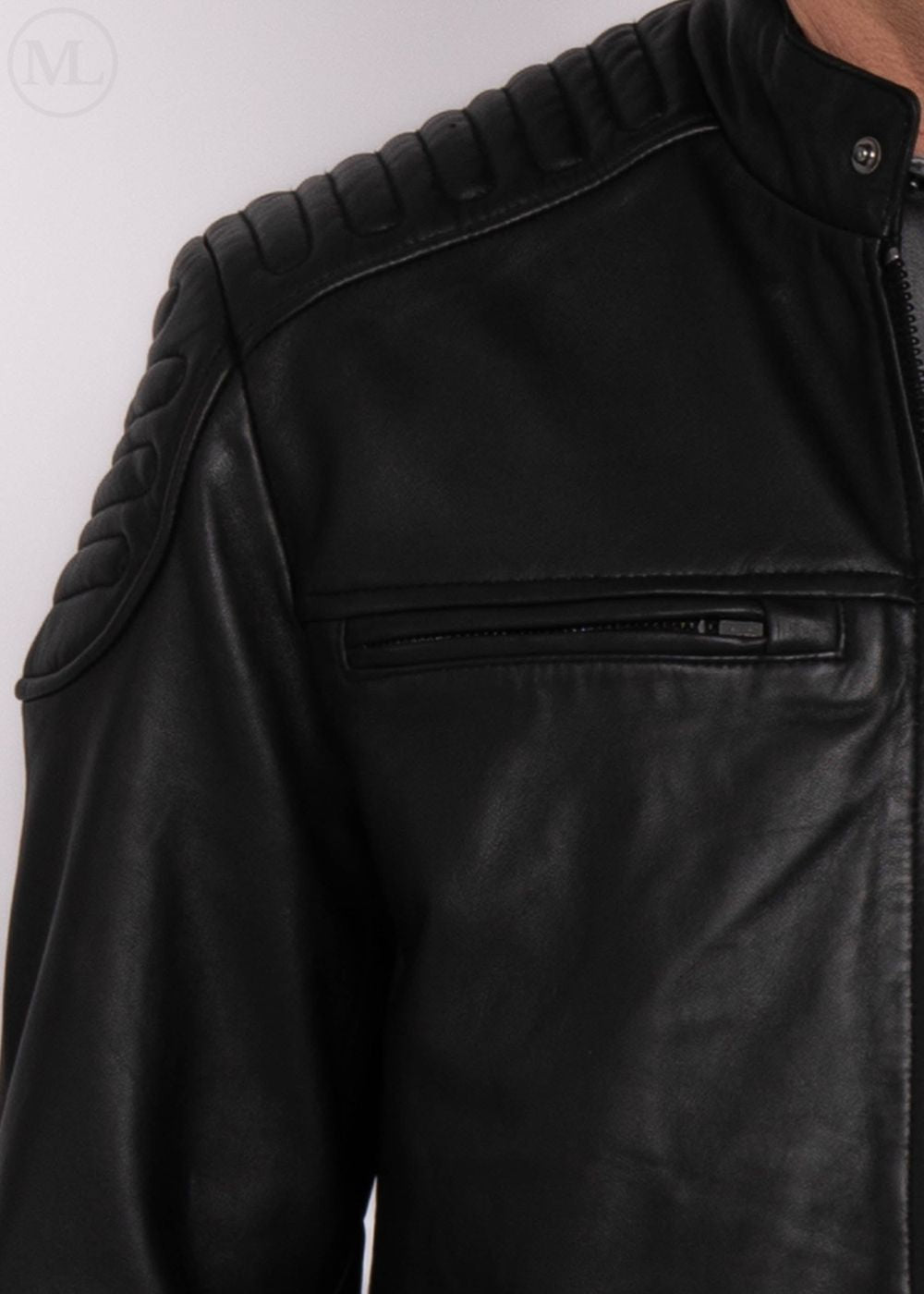 Close-up of a black leather jacket with quilted shoulder design worn by a man on a white background