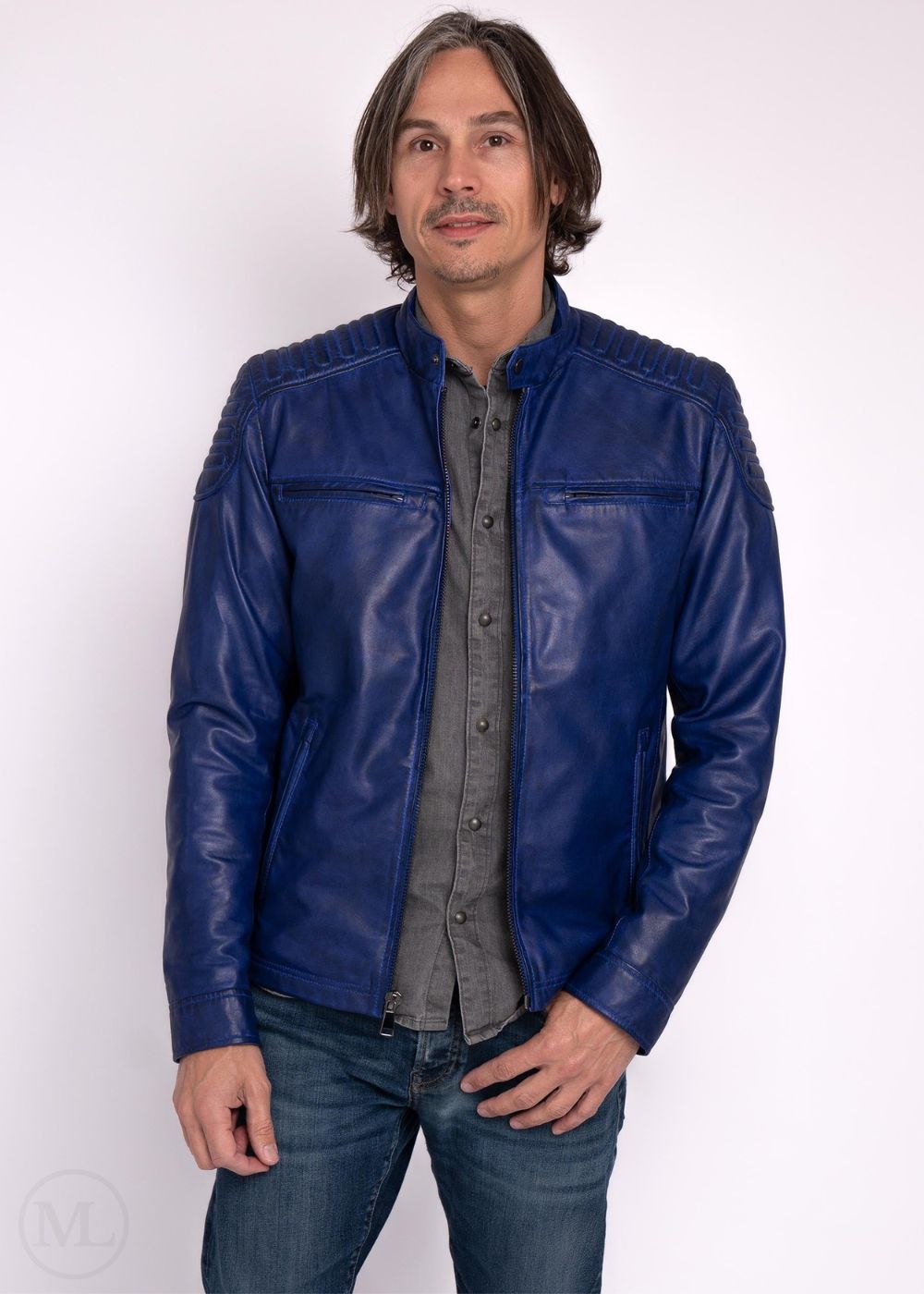 Man wearing a blue leather jacket over a gray shirt on a white background