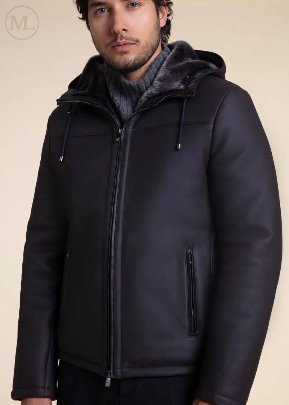 Man wearing a Dark Grey Hooded Shearling jacket with a hood on a beige background