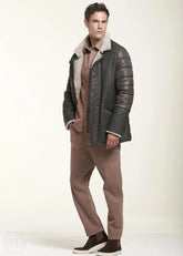 Man wearing a brown shearling leather jacket with a fur-lined hood on a white background