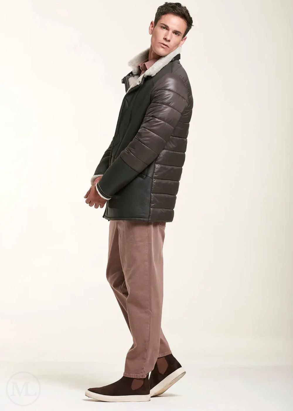 Man wearing a brown shearling leather jacket and brown pants on a white background