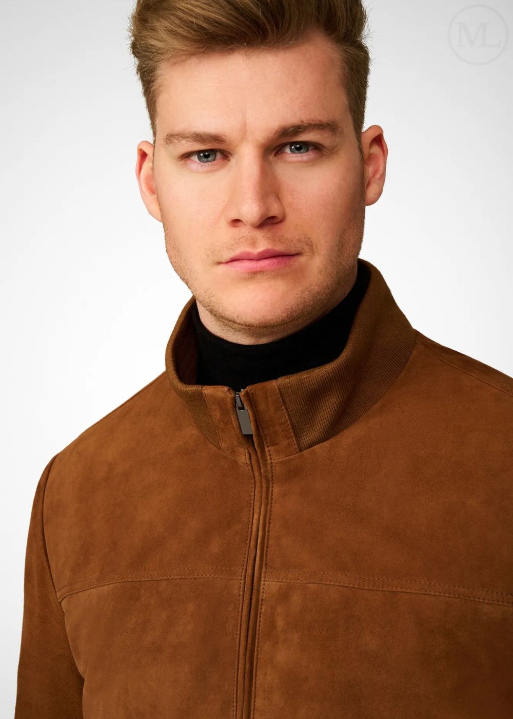 Man wearing a brown suede bomber jacket with a plain background