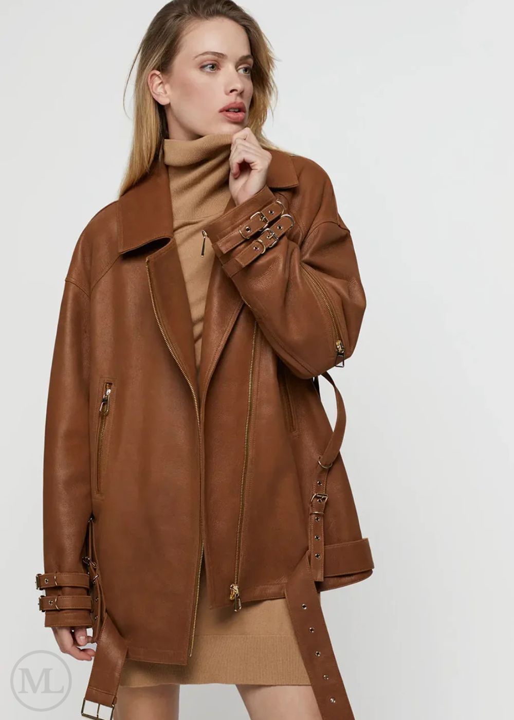 Woman wearing a caramel brown leather biker jacket on a white background