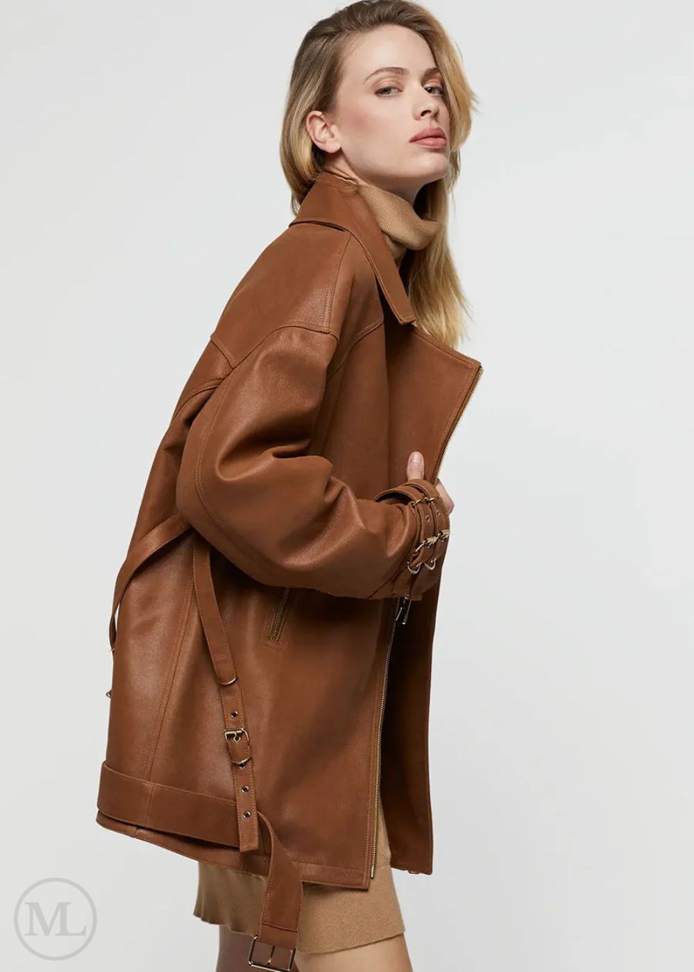 Femme portant une veste de motard en cuir marron caramel sur fond blanc