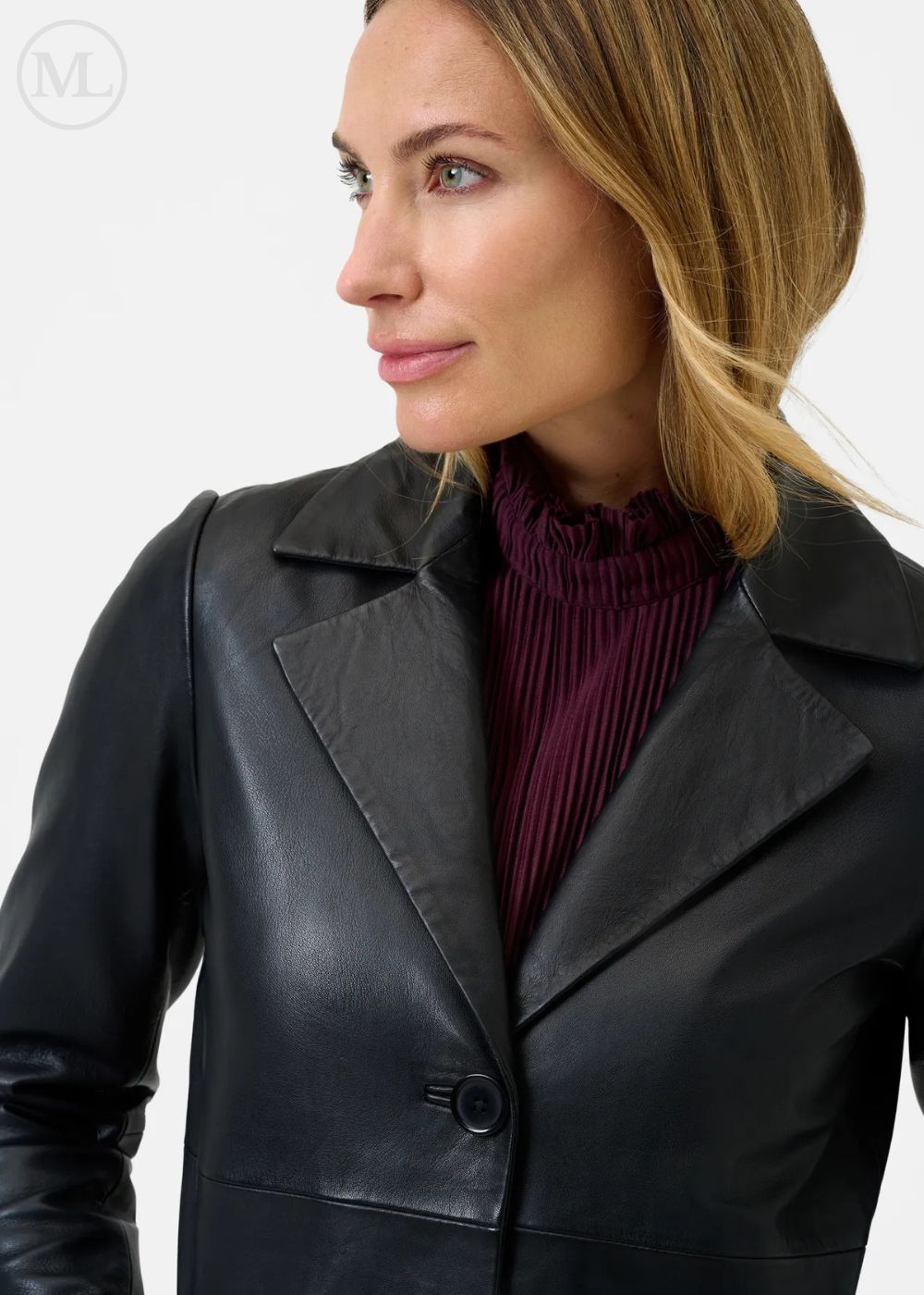 Woman wearing a black leather coat over a purple top on a white background