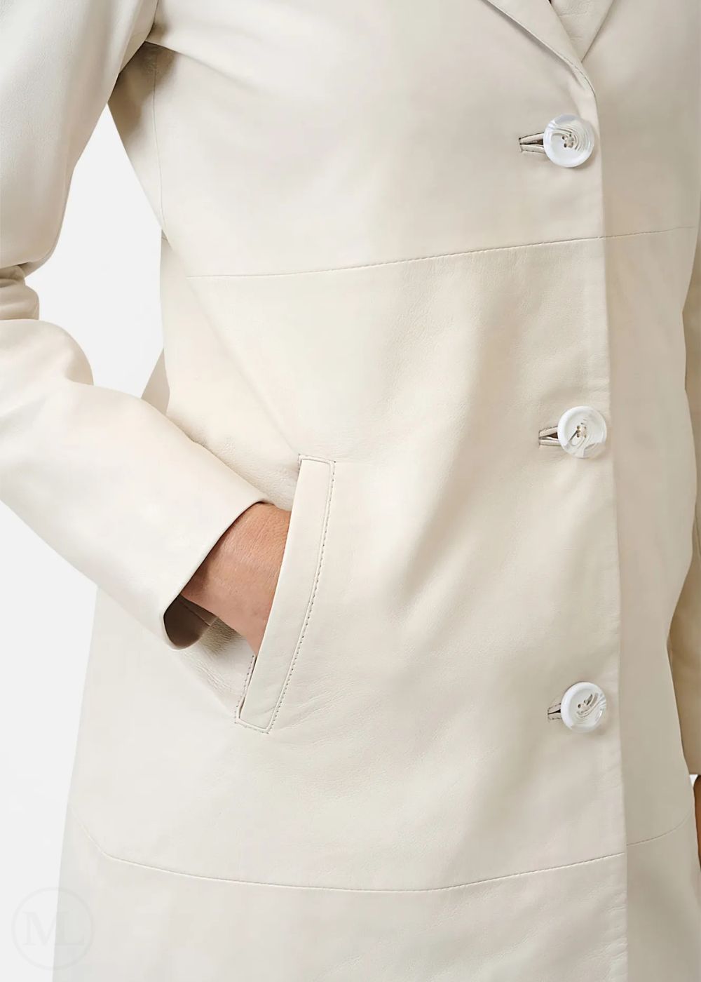 Gros plan d'un manteau ivoire avec boutons sur fond clair