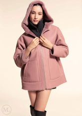 women wearing a fuschia leather hooded jacket on a beige background