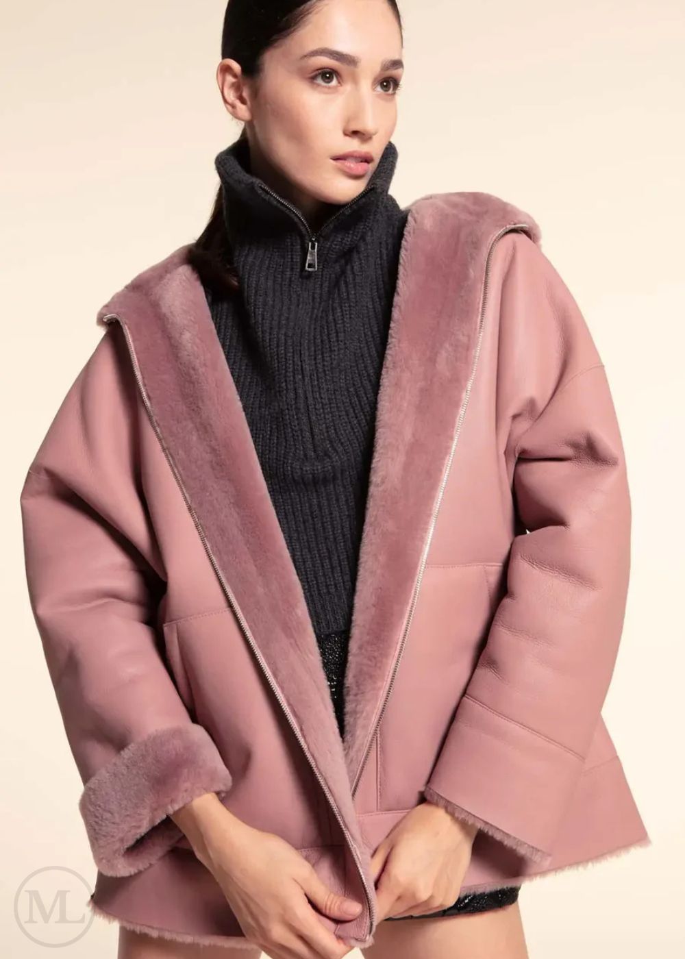 Woman wearing a fuschia leather hooded jacket with a neutral background