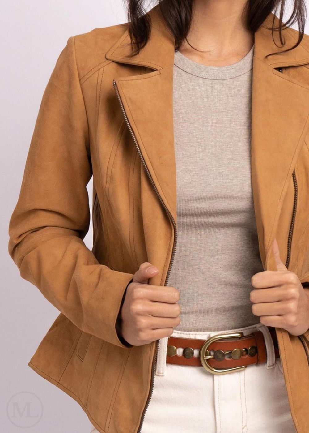 Woman wearing a camel leather jacket over a gray shirt on a white background