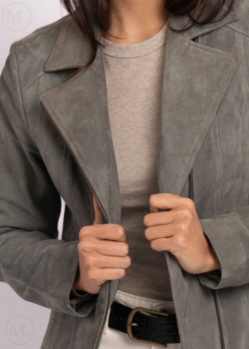 Woman wearing a gray suede jacket with a neutral background