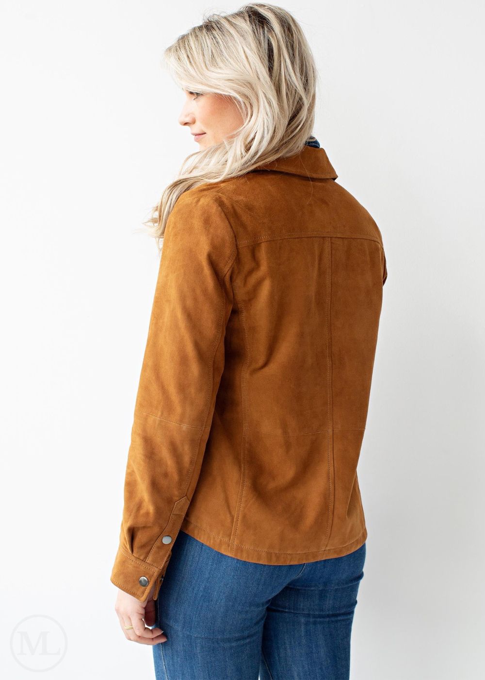 Woman wearing a cognac brown jacket and blue jeans on a white background