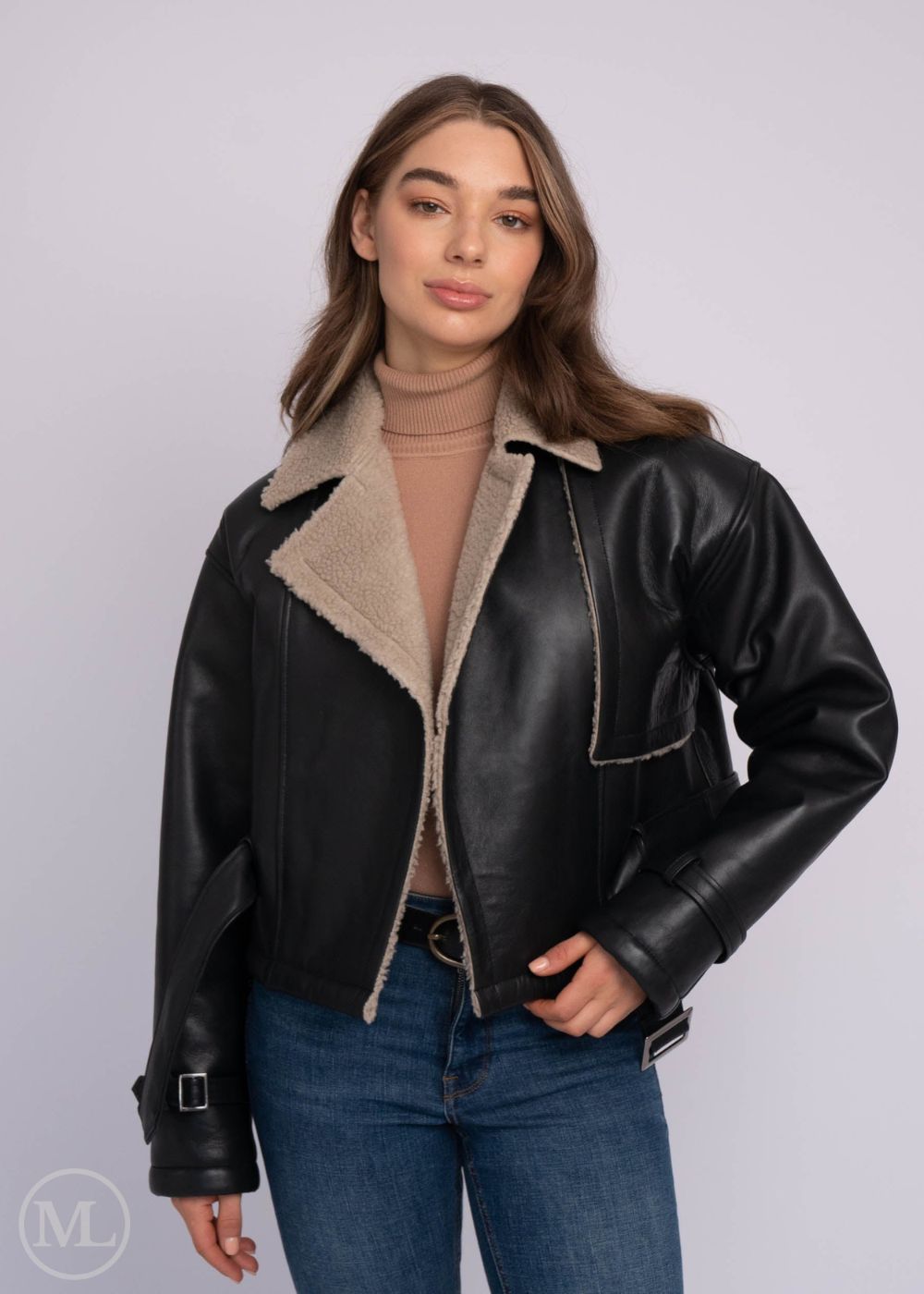 Femme portant une veste en cuir aviateur noir avec col beige sur fond blanc