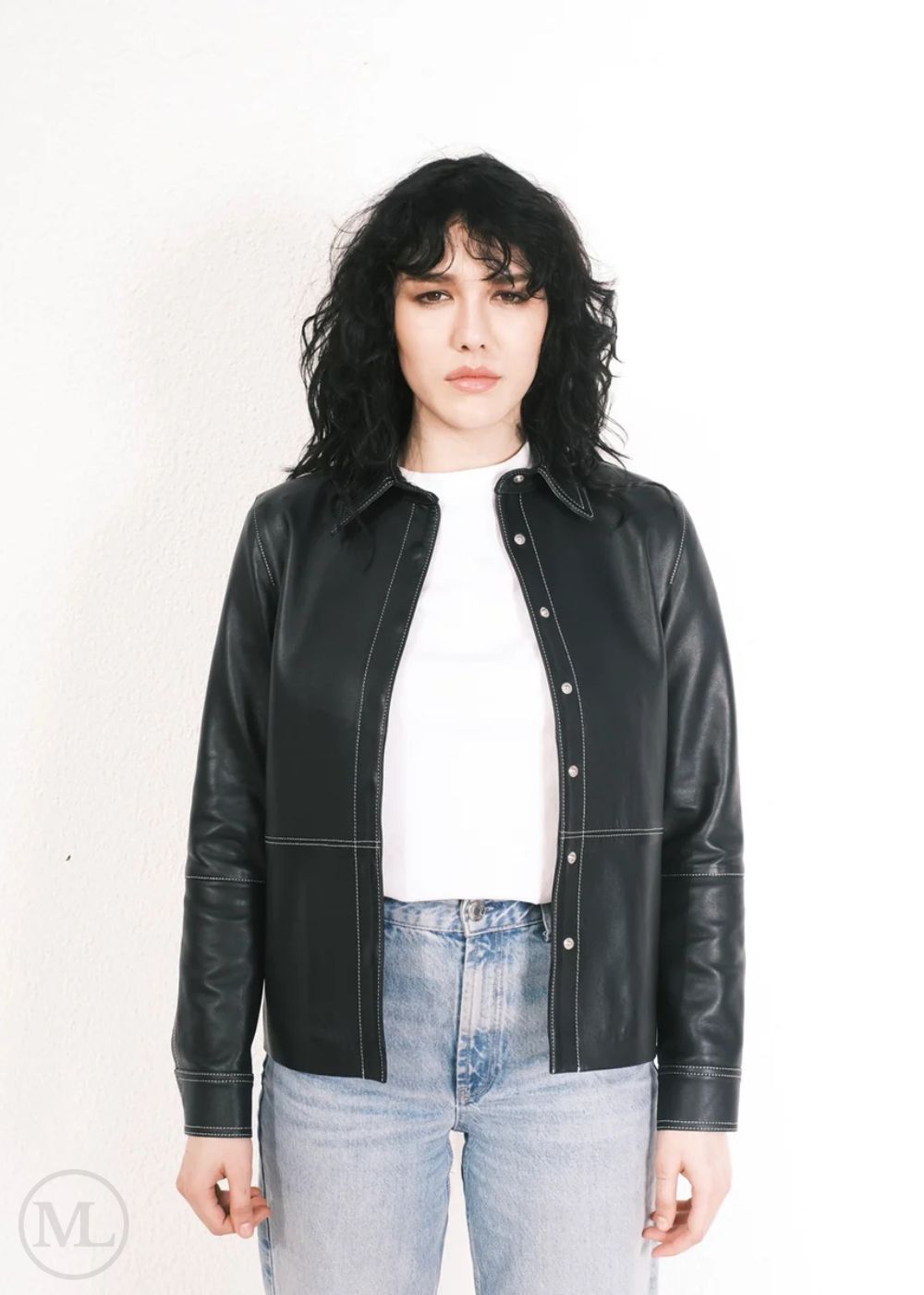 Women wearing a black leather jacket over a white shirt and blue jeans on a white background